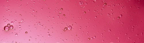 Preview: oil with bubbles on Trendy color of 2023 viva magenta. Abstract background.