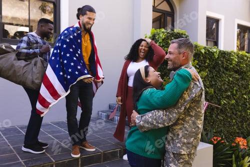 Preview: Happy diverse friends with flags welcoming home male soldier friend