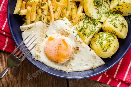 Preview: Fried egg served with potatoes and yellow beans.