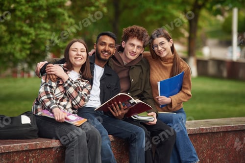 Preview: Smiling College Students Studying Together Outdoors on Campus