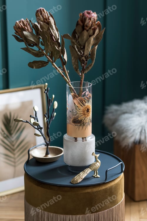 Preview: Stylish and floral composition of beautiful flowers in modern vase on the velvet pouf.