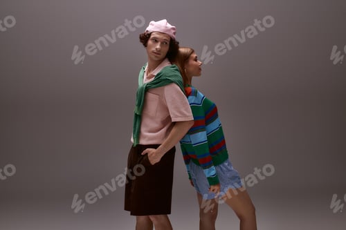 Preview: Chic young couple showcasing modern fashion in a stylish studio setting