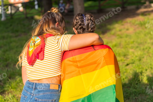 Preview: A closeup shot of two young Caucasian females holding LGBT pride flag outdoors