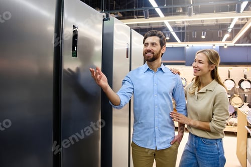 Preview: A couple is enthusiastically shopping for refrigerators at a contemporary appliance store