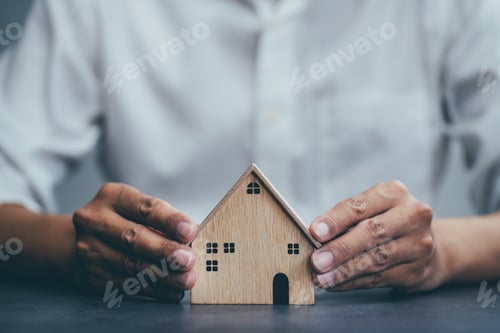 Preview: Businessman choosing house model and planning to buy property.