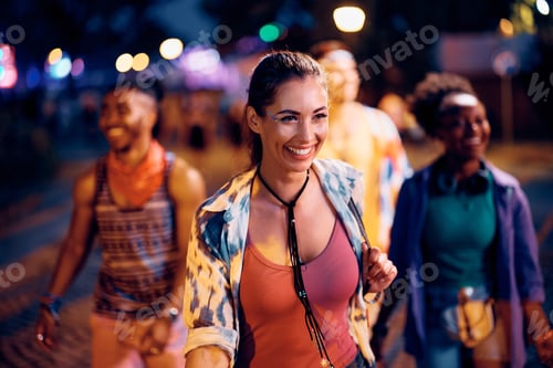 Preview: Happy festival goer and her friends having fun on music concert at night.