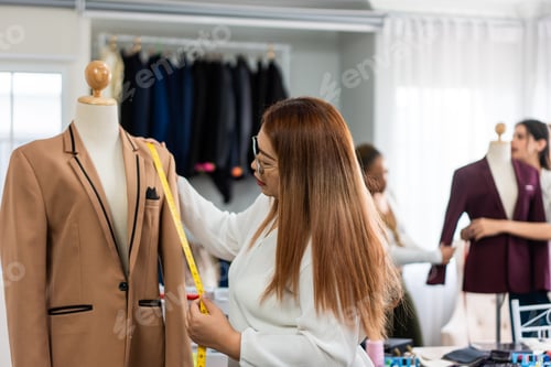 Preview: Diverse women fashion designer work design clothes in tailoring atelier.