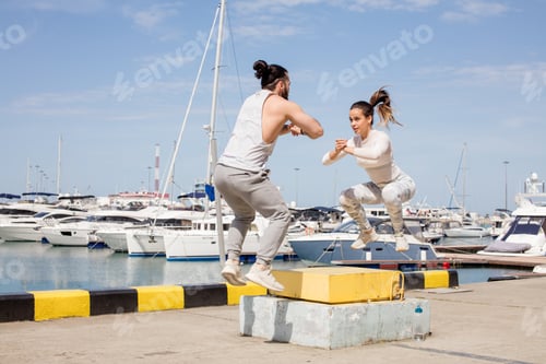 Preview: Female and male athlete is performing box jumps outdoor.