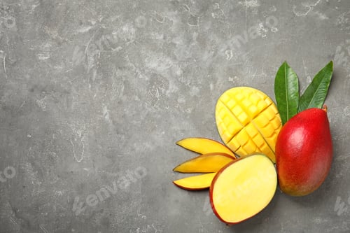 Preview: Flat lay composition with ripe mangoes and space for text on grey background