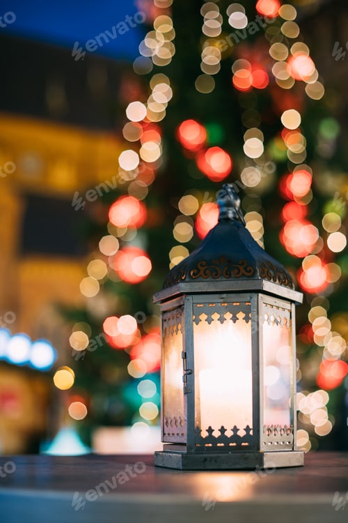 Preview: Christmas Lantern With Burning Candle On Bright Blurred Christma