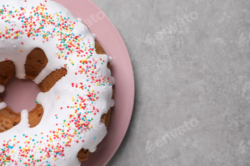 Preview: Glazed Easter cake with sprinkles on grey table, top view. Space for text