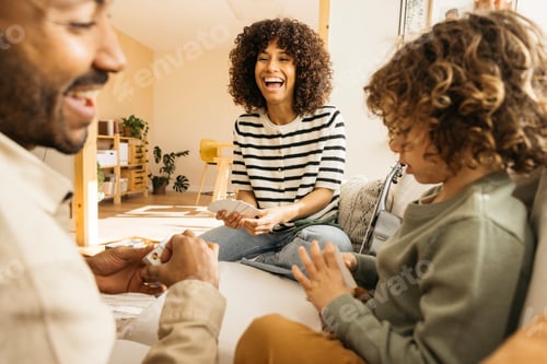 Preview: Family enjoying a playful and cheerful time together indoors playing a card game