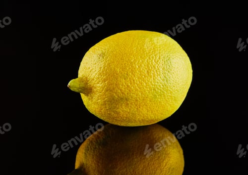 Preview: Fresh ripe yellow lemon on a black background with reflection