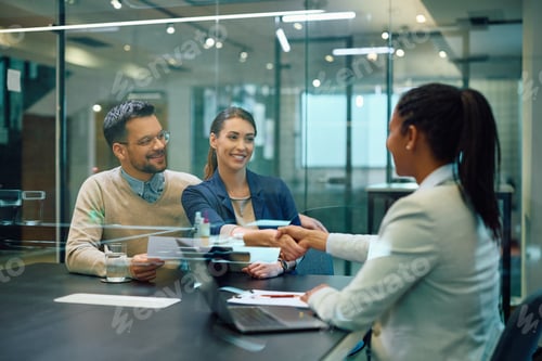Preview: Happy couple handshaking with their insurance agent after successful meeting in the office.