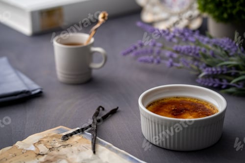 Preview: Closeup shot of a Creme Brulee and a cup of tea in the background