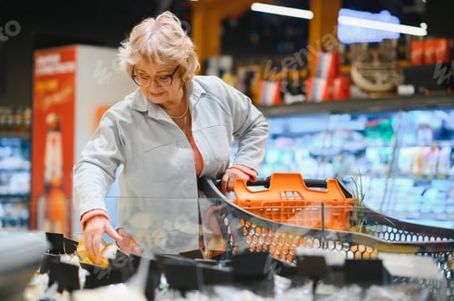 Preview: Elderly woman choose cheese in supermarket