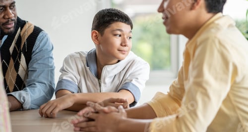 Preview: Boy student sitting at the table with teacher in the classroom