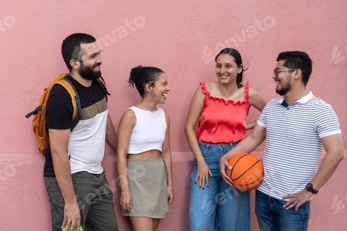 Preview: Group of friends laughing together against pink wall