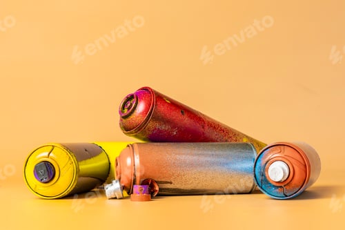 Preview: used colorful spray cans isolated on orange background b