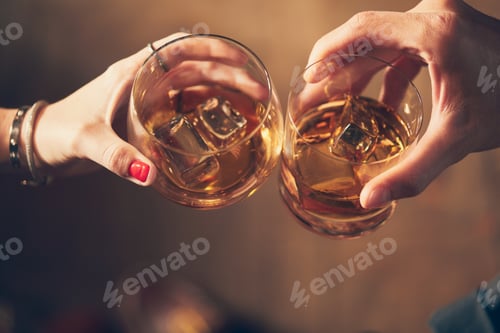 Preview: Closeup shot of two people clinking glasses with alcohol at a toast