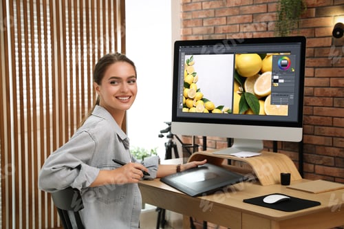 Preview: Professional retoucher working on graphic tablet at desk in office
