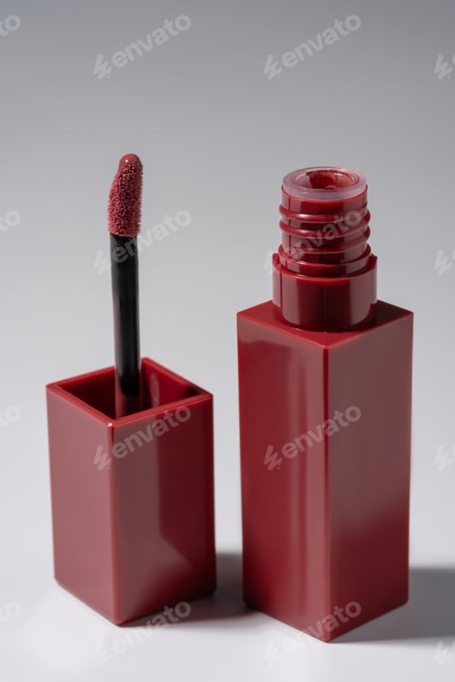 Preview: Rich red liquid lipstick product packaging and soft applicator on a neutral background.
