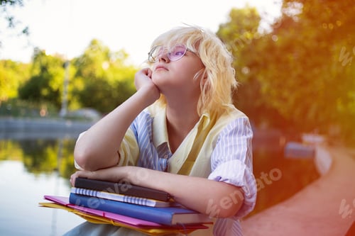Preview: Photography with teenage girl sitting with her work books and folders,concept of student life.