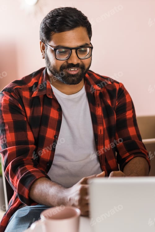 Preview: Happy indian man freelancer or entrepreneur have video conference talking, working remotely online