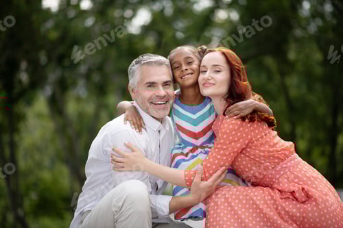 Visualização: Homem sorridente de cabelos grisalhos parado perto de esposa e filha