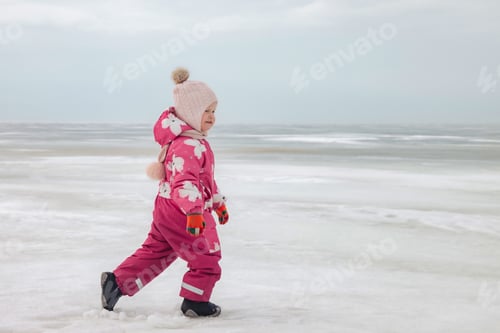 Preview: A little girl in casual clothes walking on the ice of the frozen sea