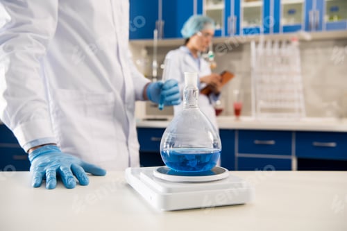 Preview: Partial view of medical worker weighing a flask with reagent in laboratory