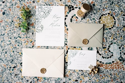 Preview: Wedding invitations next to the envelopes lie on a mosaic tile