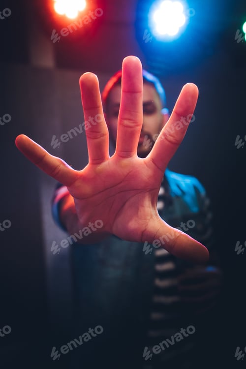 Preview: Man dancing in spotlight outstretching hand forward