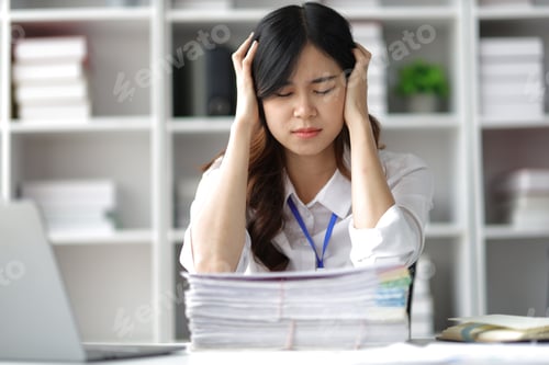 Asian women who are serious about working in the office are stressed by working.