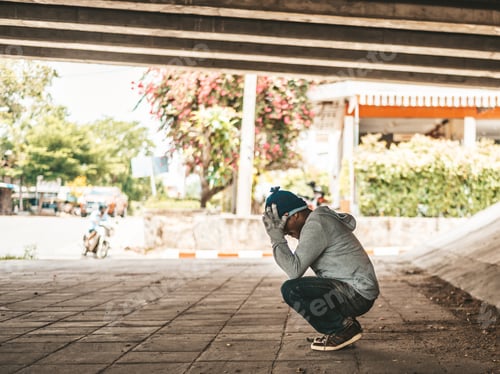 Preview: The beggars sat under the bridge with both hands holding to the head.