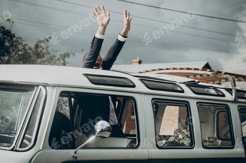 Preview: Stylish groom in retro car smiling