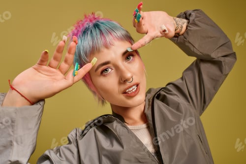 Preview: Young woman expressing joy in a colorful studio with vibrant hair