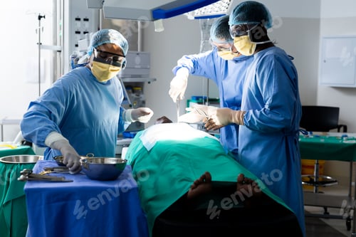 Preview: Diverse group of surgeons operating on patient in operating theatre