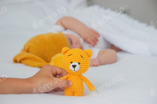 Preview: Sleeping child in bed holding teddy bear.