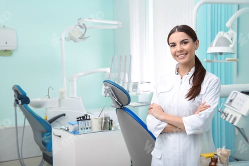 Preview: Young female dentist in white coat at workplace. Space for text