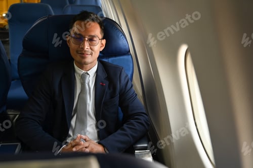 Preview: Image of pleased businessman in elegant suite sleeping in plane during business travel.