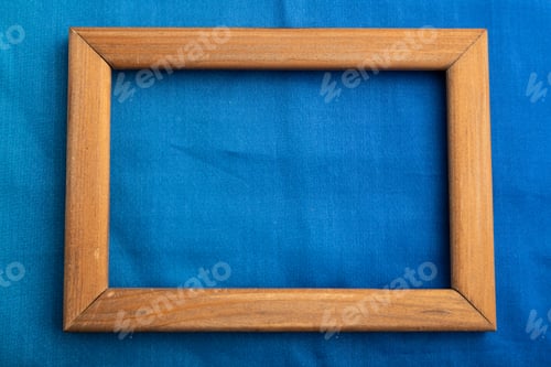 Preview: Wooden frame on smooth cotton blue tissue. Top view, natural textile background.