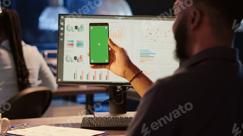Preview: Business man looking at greenscreen display on mobile phone