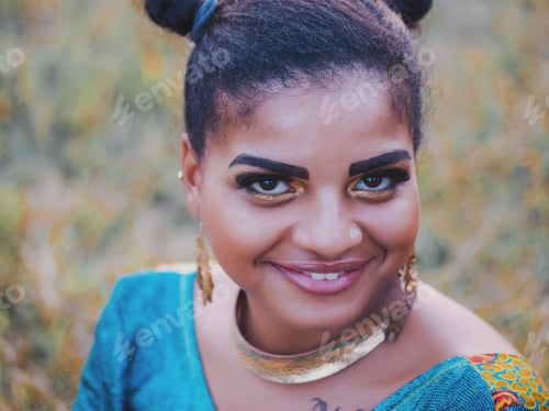 Preview: Beautiful Afro American woman in colorful dress posing outdoors
