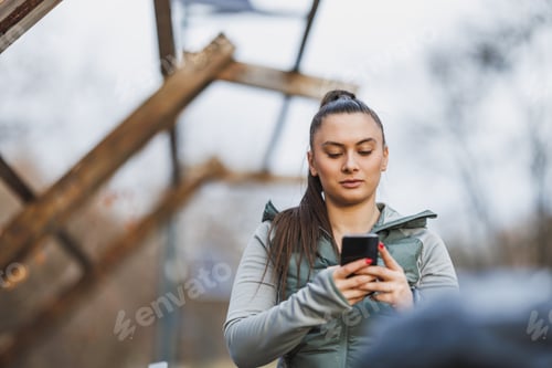 Preview: Woman Looking at Cell Phone While Engaged in Activity