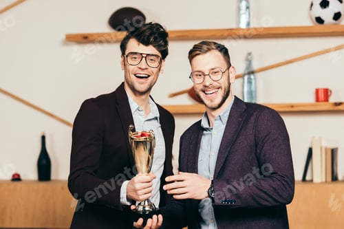 Preview: portrait of smiling businessmen with champions goblet in cafe