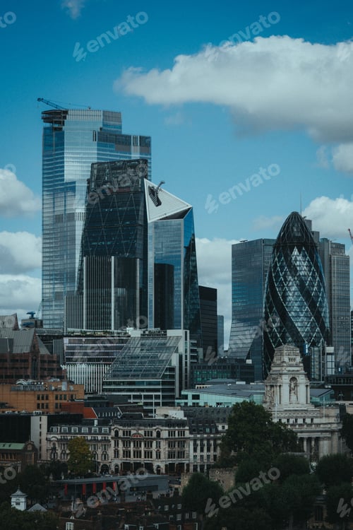 Preview: Skyline of modern skyscrapers in London's financial district under a partly cloudy sky