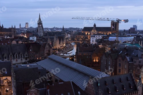 Preview: Ghent cityscape illuminating at dusk with leie river flowing through center. Belgium tourism