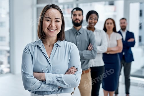 Preview: Portrait of a businesswoman standing in an office with her colleagues in the background