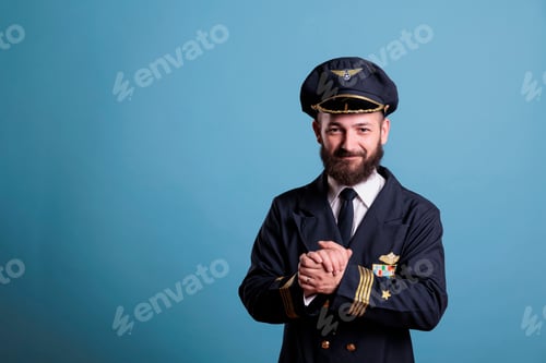 Preview: Smiling excited plane aviator in professional uniform clapping